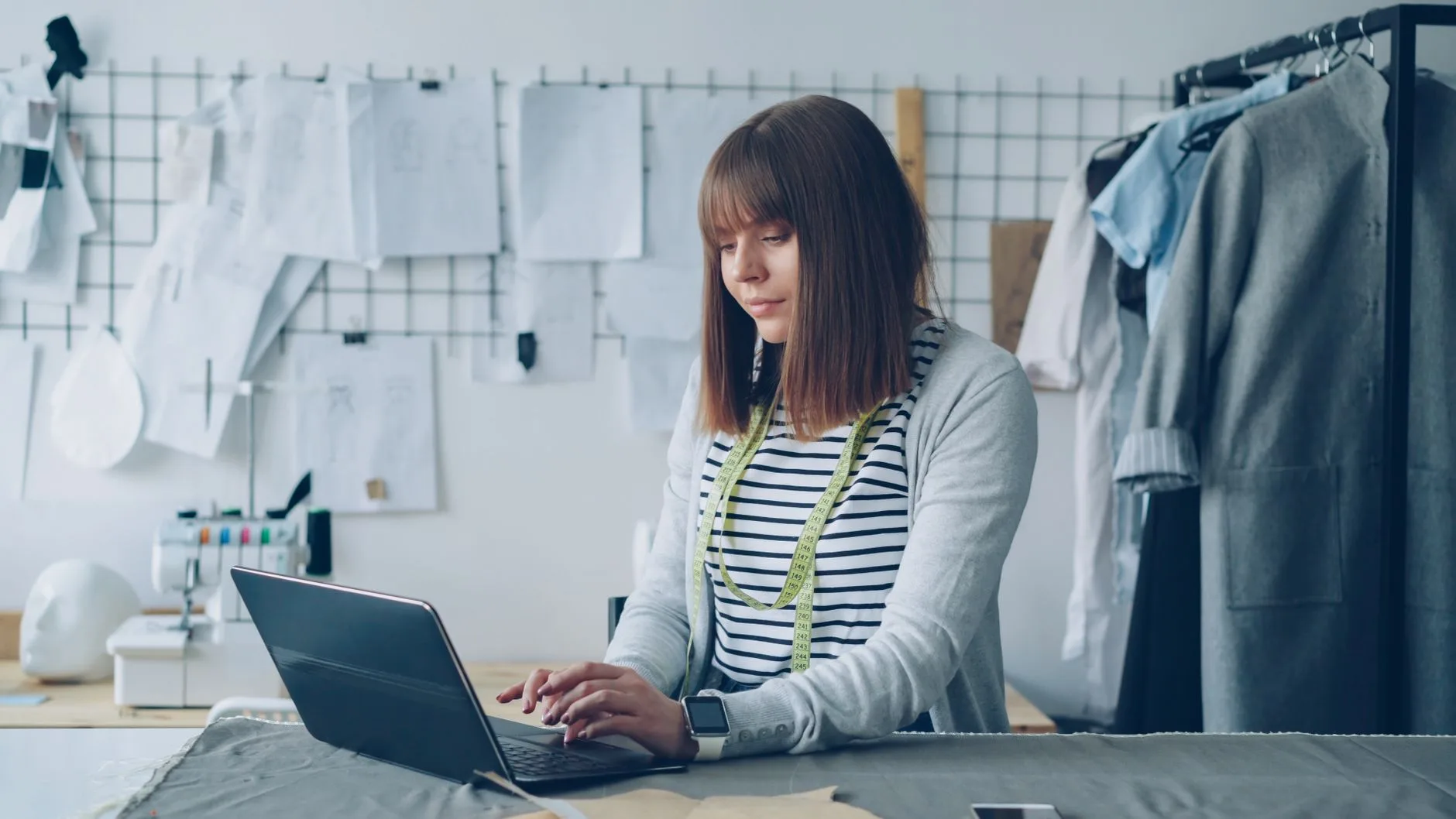 Lojista usando computador em uma boutique feminina