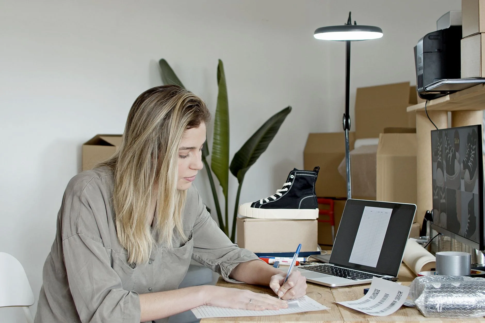 Mulher escrevendo descrição de produto no notebook