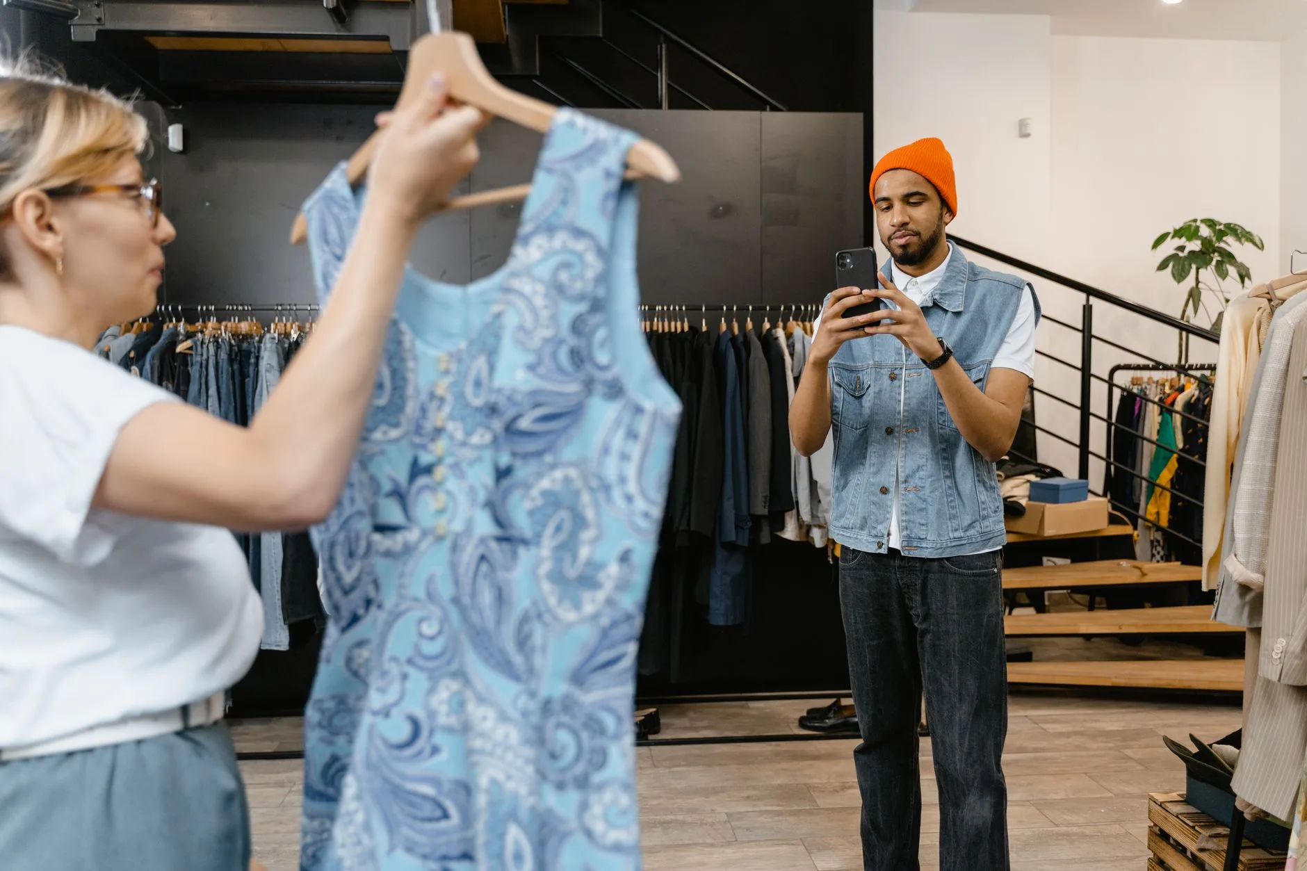 Lojista fotografando uma cliente satisfeita na boutique