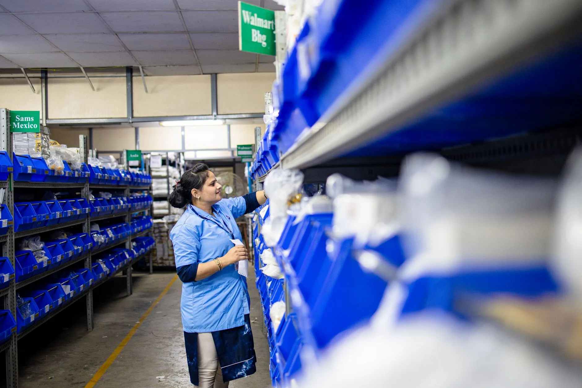 Funcionária separando roupas devolvidas no estoque