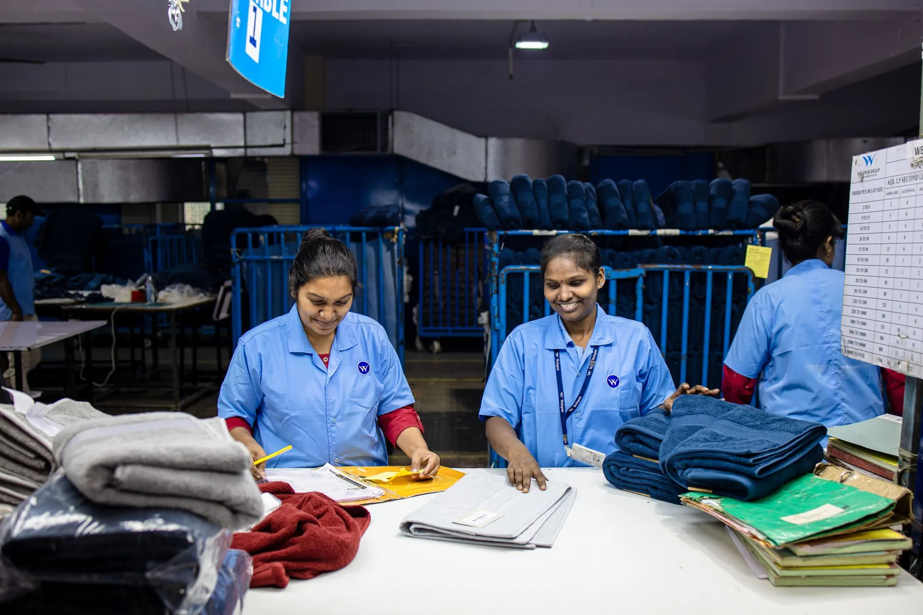 Funcionária organizando roupas dobradas nas prateleiras