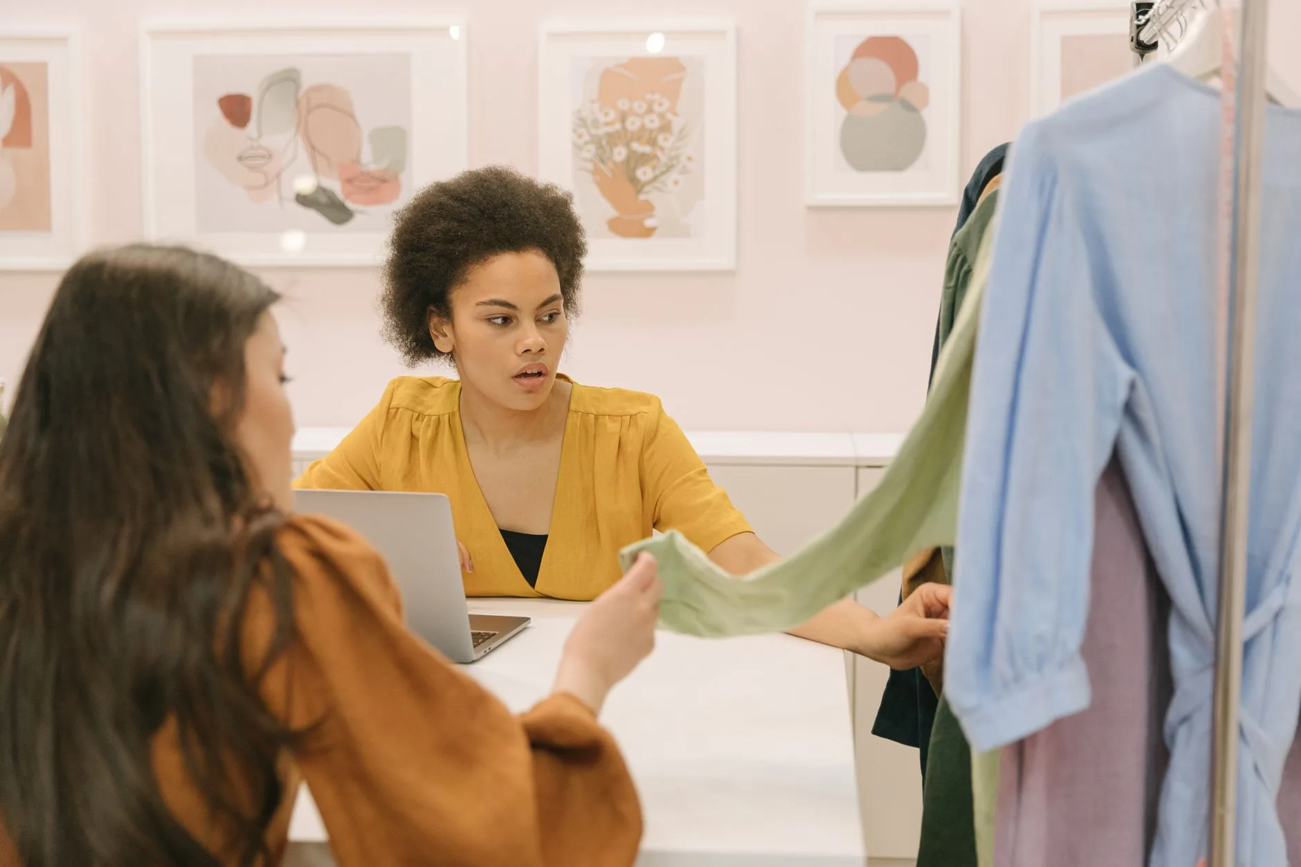 Lojista conferindo etiquetas de roupas no notebook