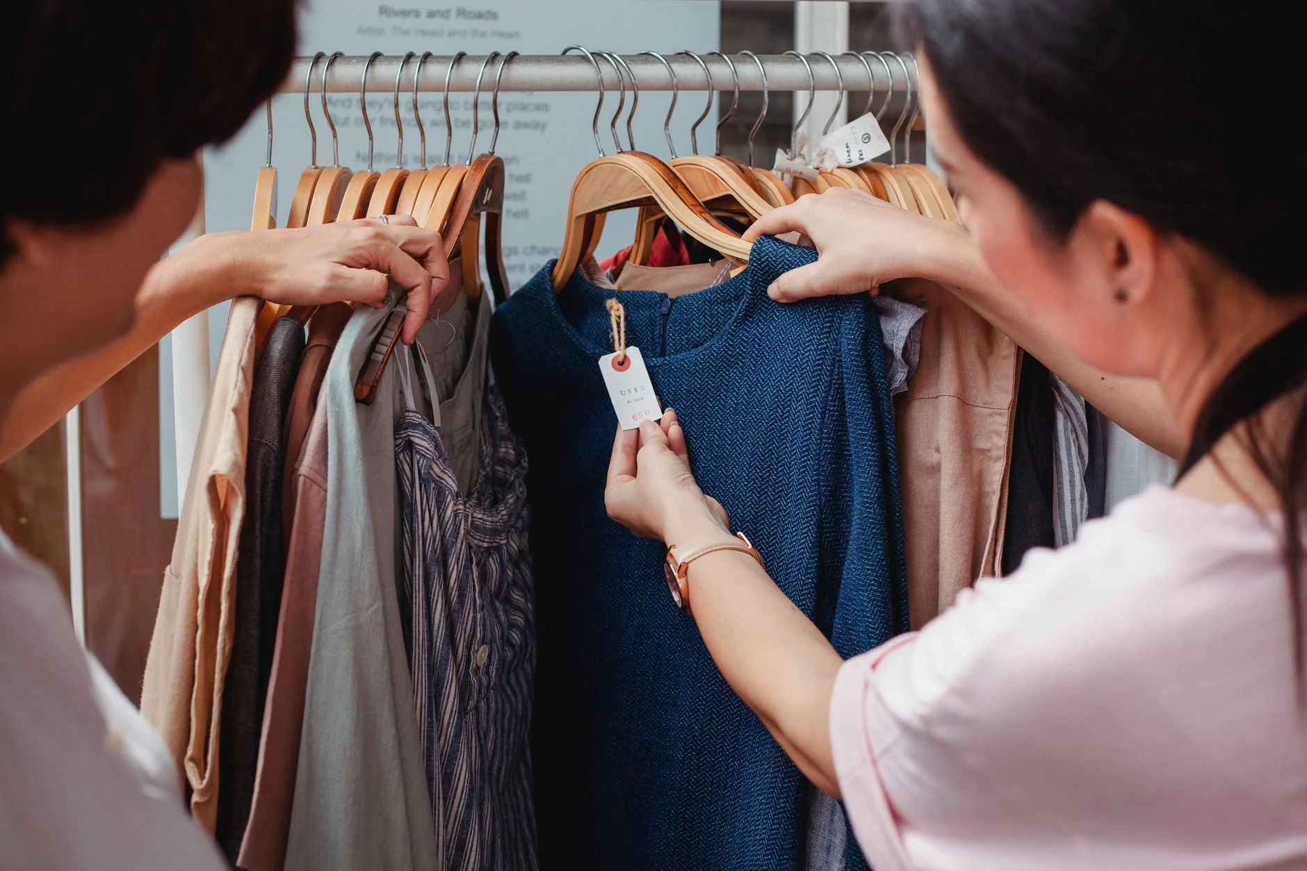 Cliente conferindo etiqueta de preço de uma roupa