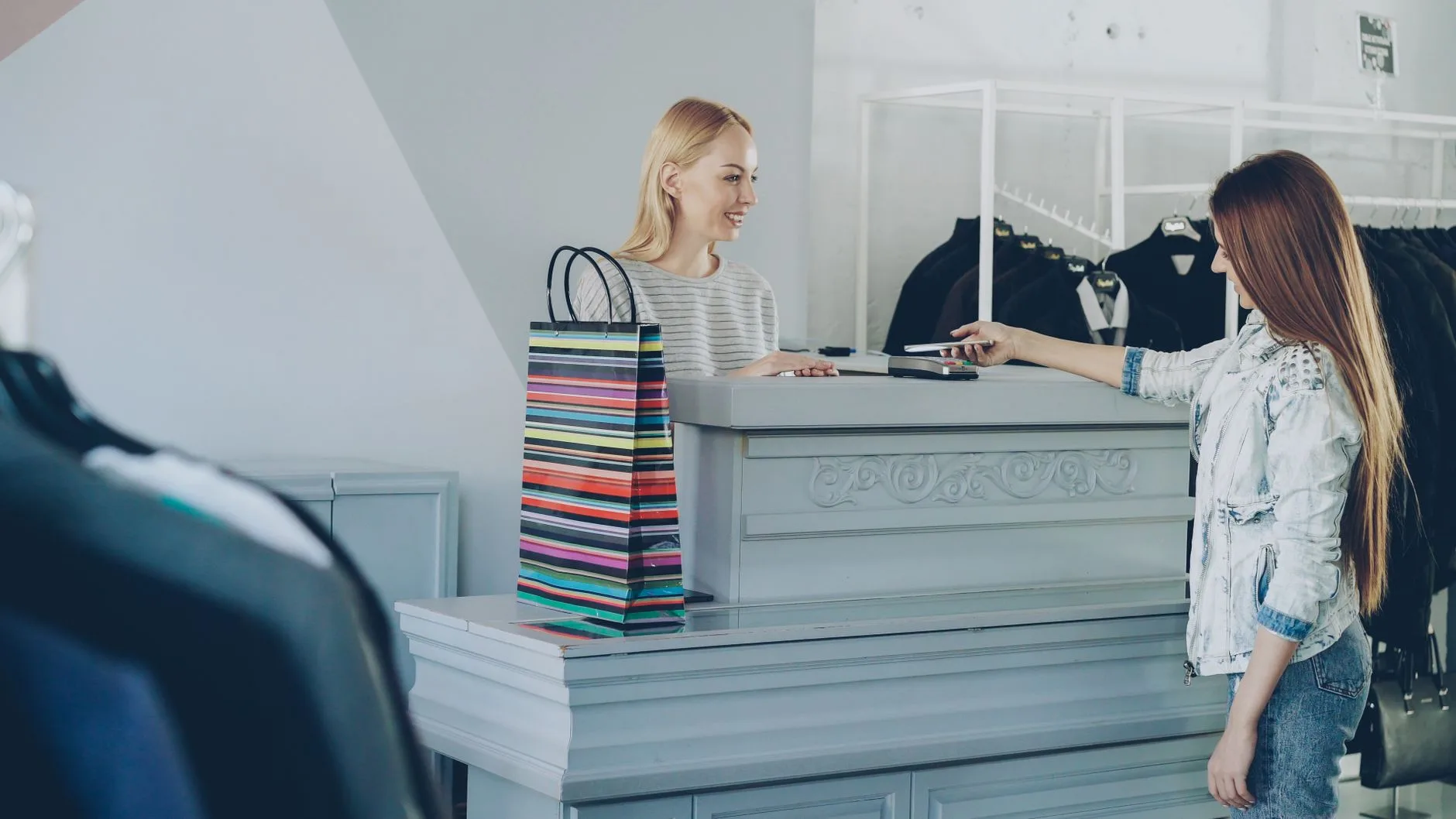 Caixa atendendo cliente em uma loja de roupas