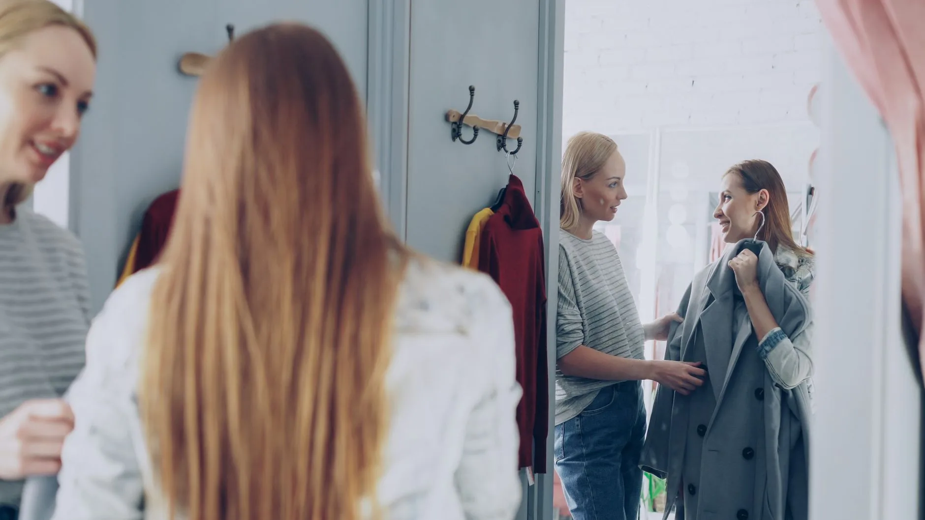 Lojista gravando um look diante do espelho da boutique